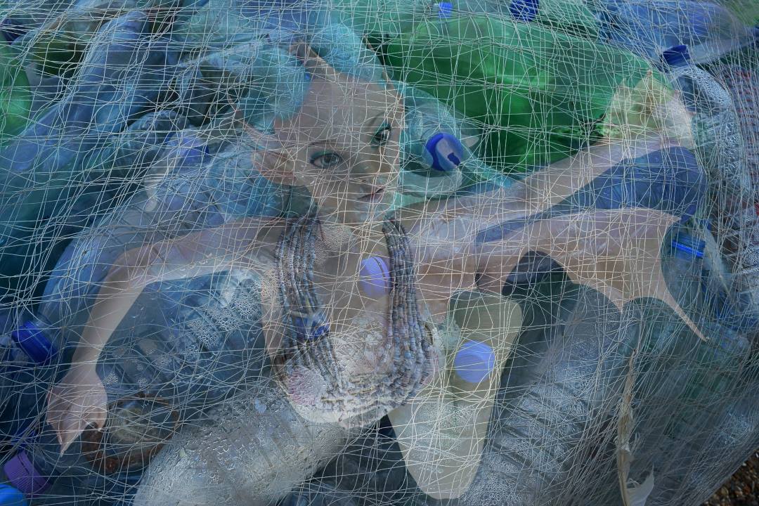 Mermaid in fishing net with plastic bottles